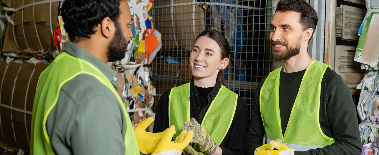 Team of workers in safety vests discussing waste management plan
